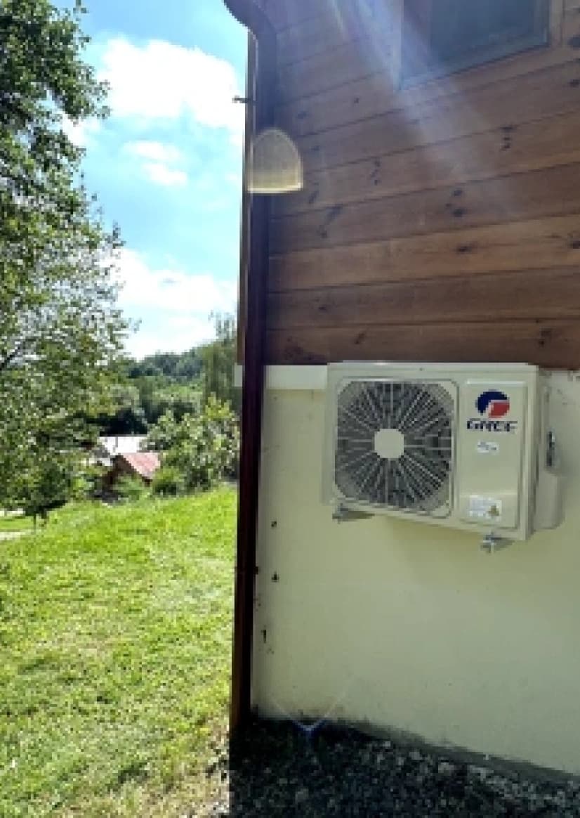Venkovní jednotka klimatizace Gree na stěně chaty