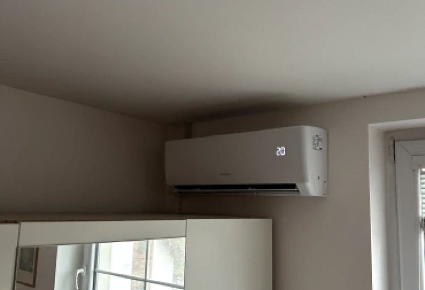 Nástěnná klimatizace Gree s displejem 20 °C v rohu obytné místnosti